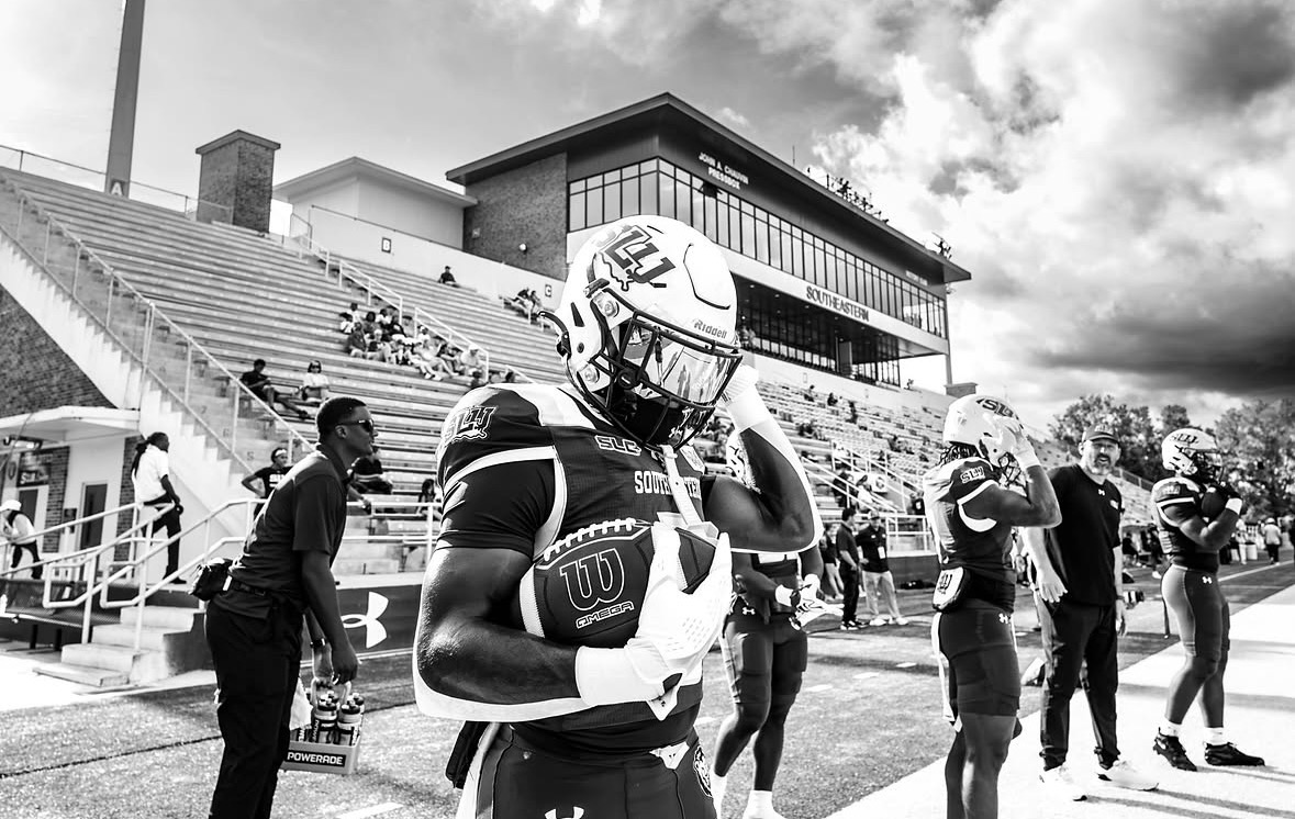Southeastern Louisiana football player holding a football on the sideline before a game
